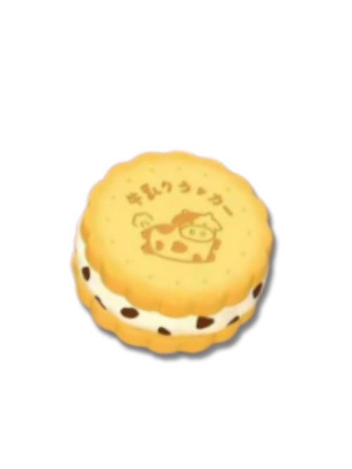 A round sandwich cookie squishy toy with cream filling and dark chocolate chips, featuring a cow illustration and Japanese text on the top, isolated on a white background.