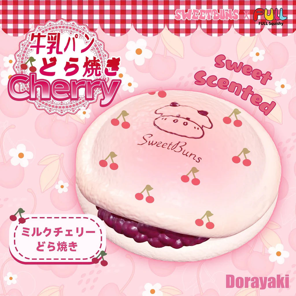 A pink Sweet Buns cherry milk cake toy or plush shown on a pink patterned background with Japanese text, including 'Cherry', 'Sweet Scented', and 'Dorayaki'. The product has a pale pink top with cherry illustrations and a dark purple filling visible between the layers.